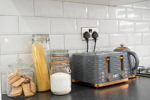 a kitchen counter with a toaster and jars of butter at Apartment - Stay 6 - Parking - PetsOK - Stratford in London
