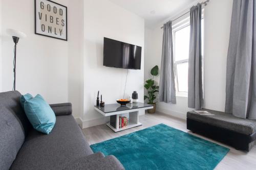 a living room with a couch and a blue rug at Apartment - Stay 6 - Parking - PetsOK - Stratford in London
