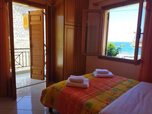 una camera da letto con un letto con due asciugamani sopra di Avra Apartments a Leonidion (Leonidio)