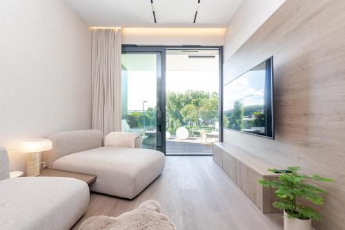 a living room with a couch and a window at Omega Lake Prestige # 5 Private Pool & Jacuzzi & Sauna & Gym & Lake Access in Olsztyn