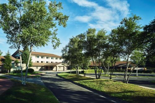 an empty street with trees in front of a building at ANA Holiday Inn Resort Karuizawa by IHG in Kita-karuizawa