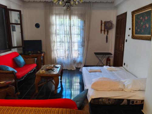 a bedroom with two beds and a couch and a table at Apartment with Garden in Amarinthos
