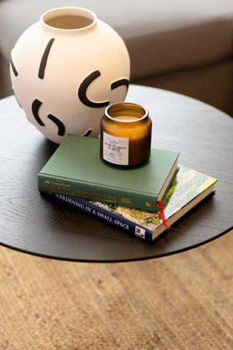 a stack of books with a vase and a candle at Luxury Apartment, Birmingham-Parking in Birmingham