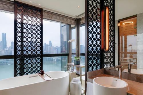 a bathroom with two sinks and a tub and a large window at Regent Chongqing - Complimentary 1st round mini bar daily in Chongqing