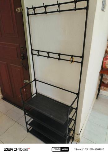 a black shelf in a room next to a door at Homestay D'Lapang near KLIA in Sepang