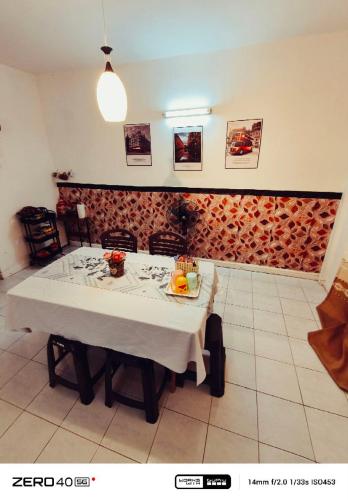 a dining room with a white table and a brick wall at Homestay D'Lapang near KLIA in Sepang