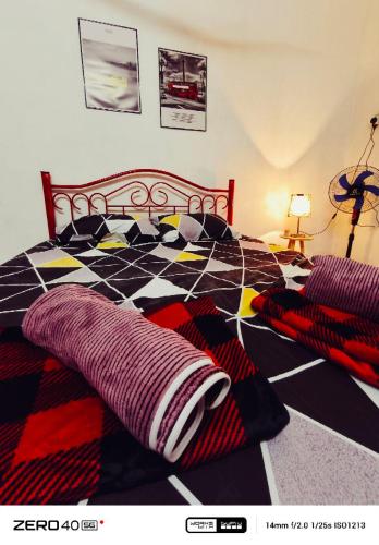 a bedroom with a checkered bed with pillows at Homestay D'Lapang near KLIA in Sepang