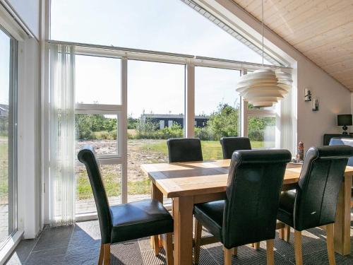 a dining room with a wooden table and black chairs at 4 star holiday home in Brovst in Brovst