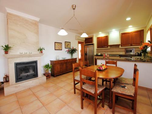 a kitchen and dining room with a table and a fireplace at Villa in Mallorca with Private Pool in Marratxi