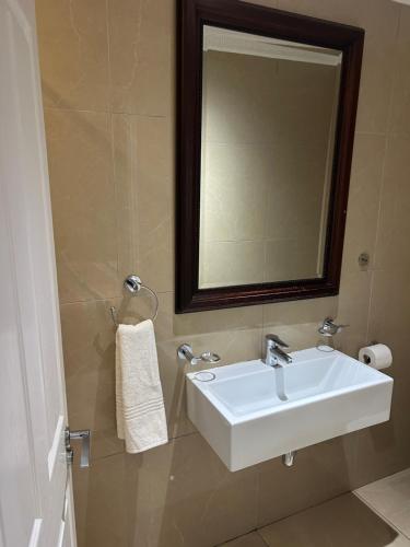 Un baño con un lavabo blanco y un espejo. en Seaview Apartments -Near MSC Cruise Terminal and UShaka Marine, en Durban