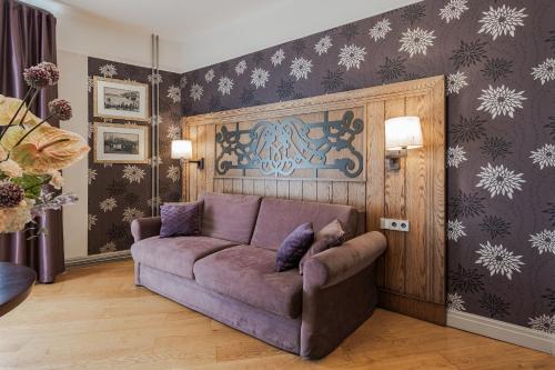 a living room with a purple couch in a room at Eurostars Metropole in Rīga
