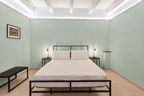 a bed in a white room with two side tables at Dimora Storica Lucia in Ascea