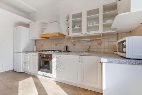 a kitchen with white cabinets and a stove top oven at Exclusive Apartment in Centre in Bratislava