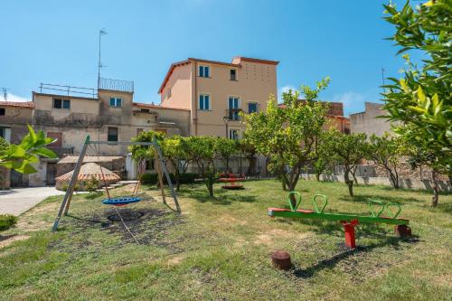 a yard with swings and trees and a building at Dimora Storica Lucia in Ascea