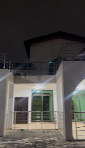 a white house with a balcony in front of it at Luxe on the lane in Kwedonu