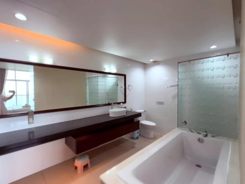 a bathroom with a tub and a sink and a mirror at Căn Hộ OCEAN VISTA View Biển 1,2,3 phòng ngủ in Ấp Ngọc Hải