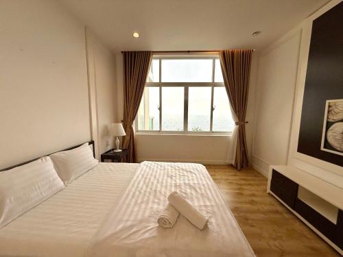 a bedroom with a bed with a pair of shoes on it at Căn Hộ OCEAN VISTA View Biển 1,2,3 phòng ngủ in Ấp Ngọc Hải