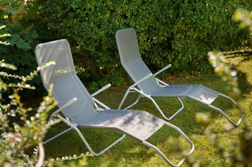 two blue lawn chairs sitting in a yard at Ferienwohnung Sonnenblick in Putbus
