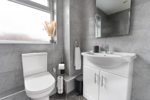 a bathroom with a white toilet and a sink at City Centre House with Secure Driveway Parking, Neflix, Garden, Long Stay Savings in Liverpool