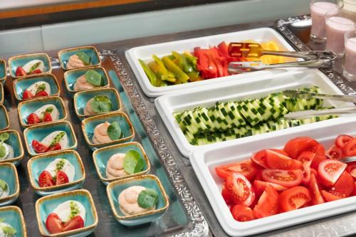 two trays filled with vegetables on a table at Hotel Kálvária in Győr