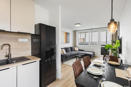 a kitchen and a living room with a table and a couch at Cloud Apartment in Koliba