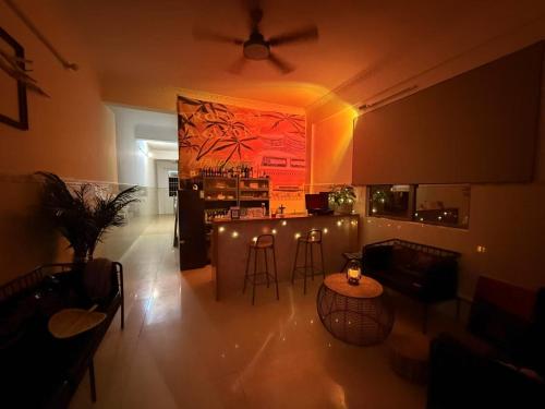 a living room with a bar with lights and chairs at Dongfang City Erlihai Youth Hostel 