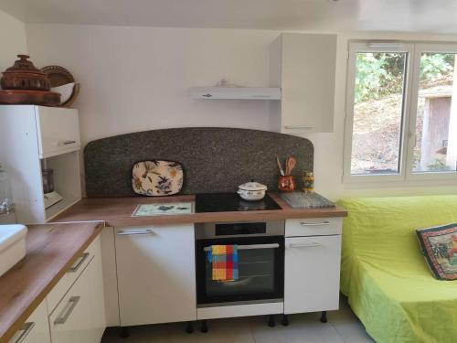 eine Küche mit Theke und Herd Oberer Backofen in der Unterkunft La maison de Quitterie in Aire-sur-lʼAdour