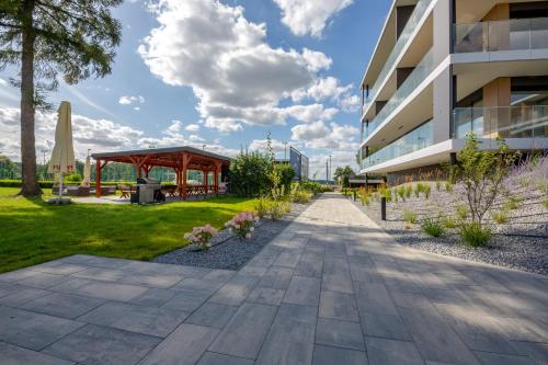 a walkway next to a building with a gazebo at Omega Lake Prestige # 5 Private Pool & Jacuzzi & Sauna & Gym & Lake Access in Olsztyn