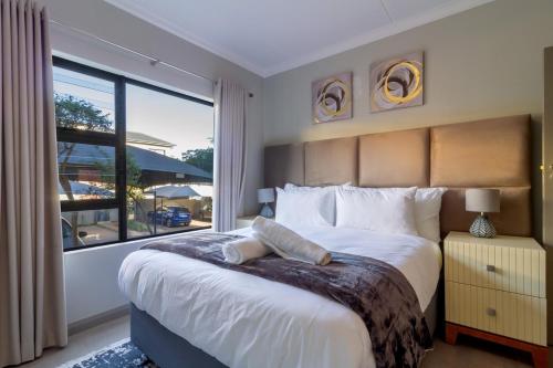 Un dormitorio con una cama grande y una ventana grande. en #AlimamaSpaces The Manson Umthunzi View, en Vosburg