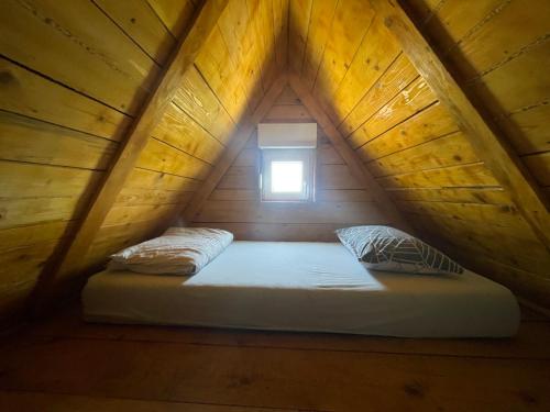 Bett in einem Holzzimmer mit Fenster in der Unterkunft Kuća sa Pogledom in Sremski Karlovci