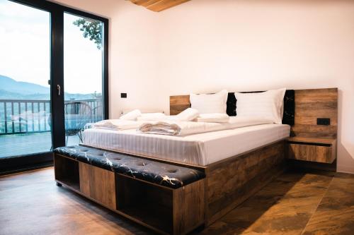 Un dormitorio con una cama grande y una ventana grande. en Cabana Sub Stejari 2, en Râșnov