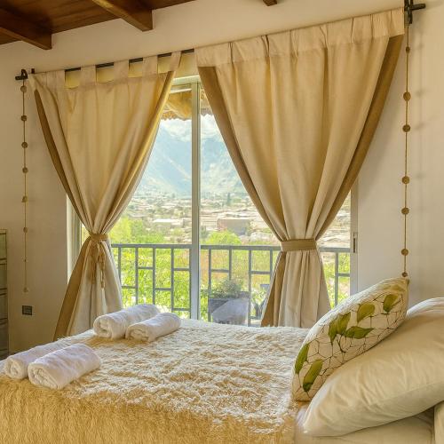a bedroom with a bed and a large window at La Casita de Orfi in Calca