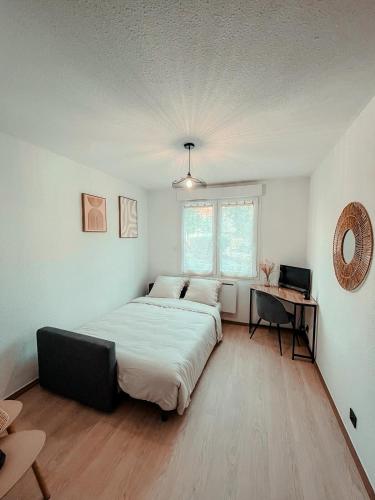 a bedroom with a large bed and a desk at Studio du voyageur, Gare, Centre, Europole, CEA in Grenoble