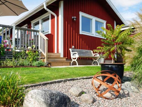 a red house with a bench in front of it at 4 person holiday home in ONSALA-By Traum in Onsala