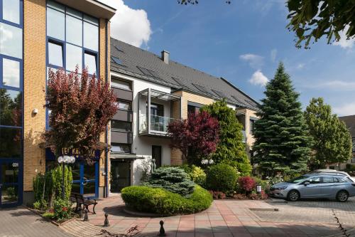 a house with a car parked in front of it at Hotel Kálvária in Győr