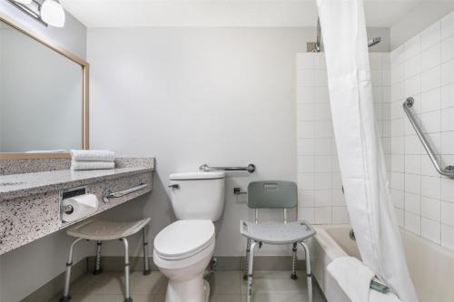 a bathroom with a toilet and a sink and a tub at Best Western Prince George Downtown in Prince George