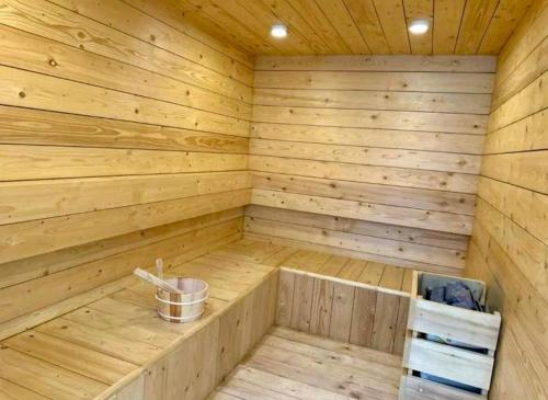 a wooden sauna with a bucket in it at Luxe 1BHK Apartment with Pool and Sauna in Islamabad