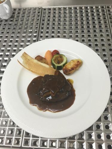 a plate of food with meat and vegetables on a table at Auberge Le Meisenberg in Châtenois