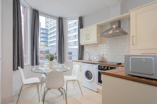 a kitchen with a table and chairs and a microwave at Camden Luxe Apartments in Belfast