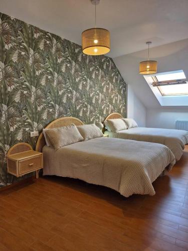two beds in a room with a wall at Apartamento Mar y Rocas in Malpica