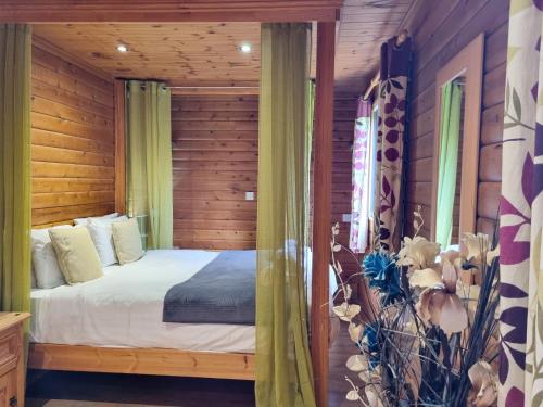 a bedroom with a bed and a wooden wall at Oak 10 Hot Tub in Garton