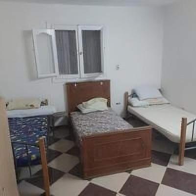 two beds in a room with a checkered floor at Beachfront Villa 3 bedroom 3 bathroom قرية مرحبا بيتش in Banī Ghālib