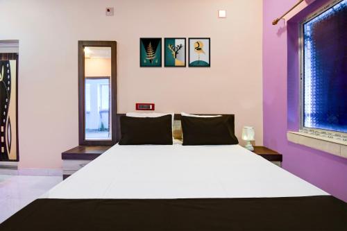 a large white bed in a room with purple at Hotel O MANTRA in Krishnanagar
