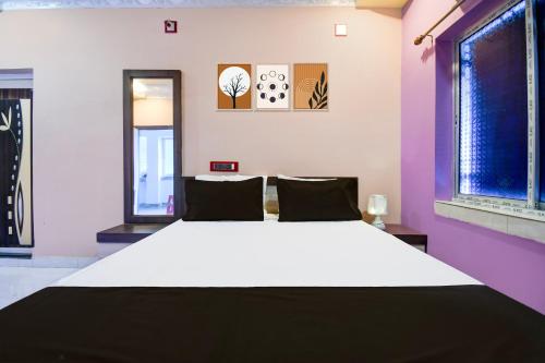 a large bed in a room with two windows at Hotel O MANTRA in Krishnanagar