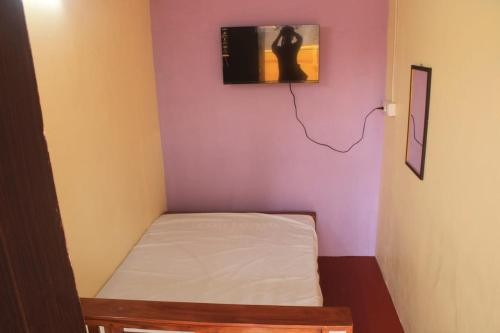 a small room with a bed and a picture on the wall at Villa Lune Home Stay in Puducherry