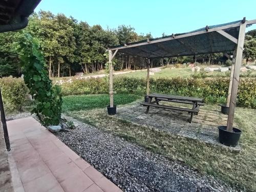 a picnic bench under a canopy in a park at Casa vacanze "LA FORNACE" in Vagliagli
