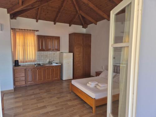 a small kitchen with a bed and a refrigerator at Eptanisa Hotel in Mikros Gialos