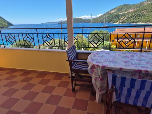 a balcony with a table and a view of the water at Eptanisa Hotel in Mikros Gialos