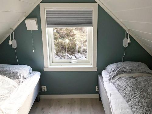 a bedroom with two twin beds and a window at 8 person holiday home in Urangsvåg in Ervik