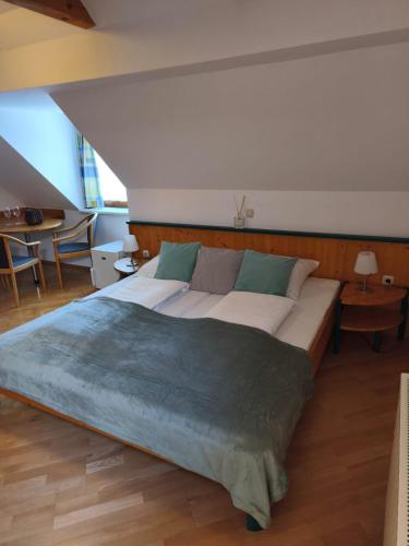 a bedroom with a large bed and a table at Gasthof Buchgraber in Edelsbach bei Feldbach